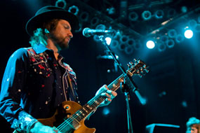 Jeff Massey of The Steepwater Band playing a goldtop Les Paul guitar and wearing a sharp fedora